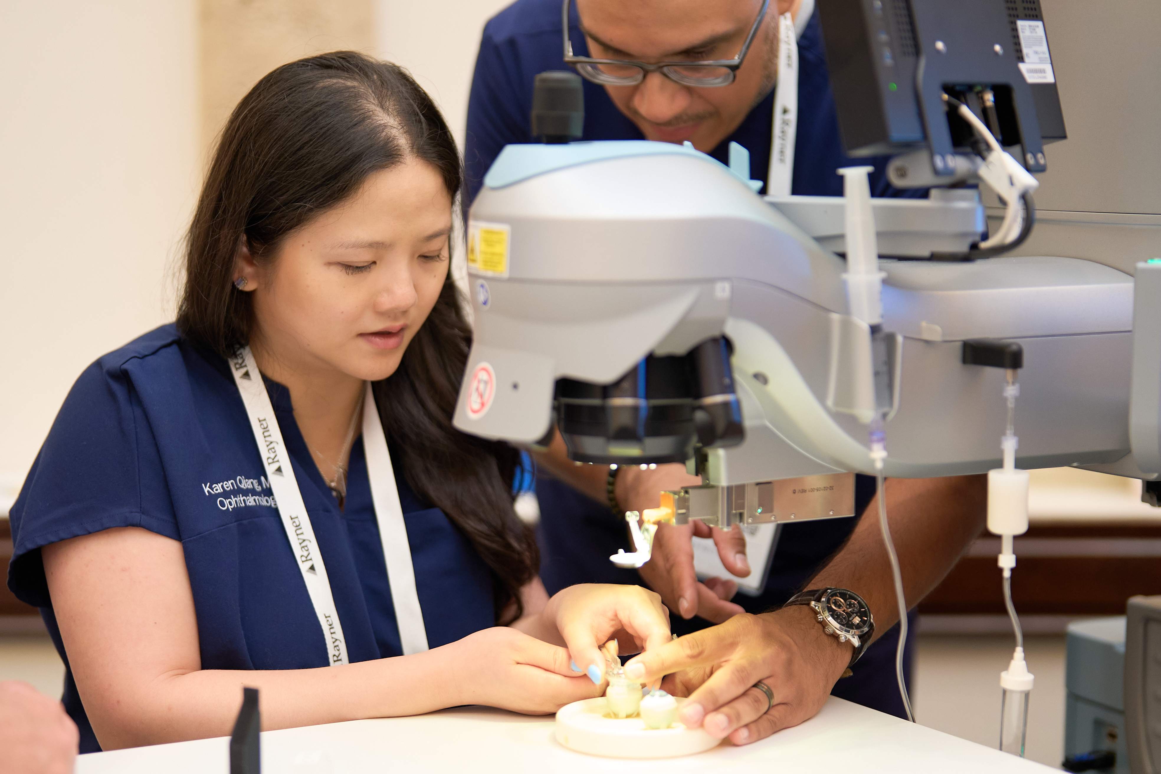 An Eyeprentice faculty member guiding a resident through a surgical wet-lab exercise at the microscope